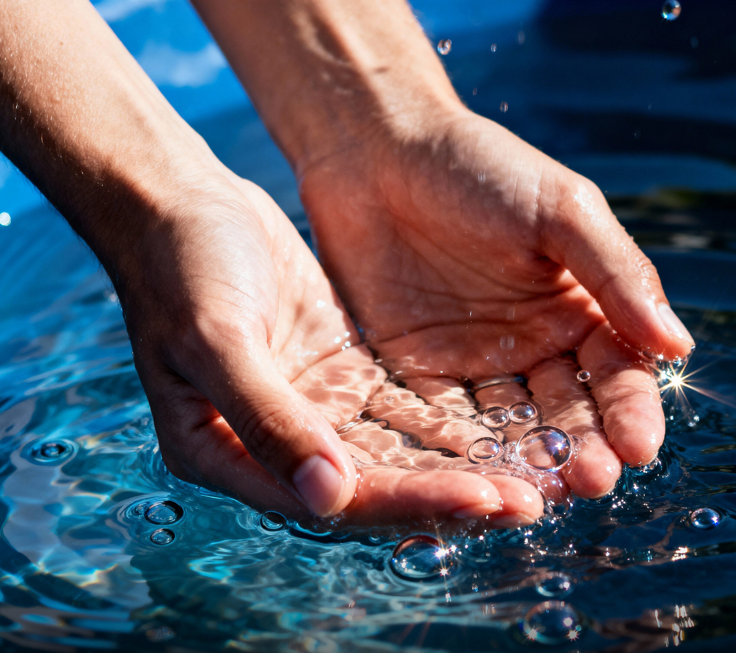 AquaPurix Hände heben etwas Wasser aus einer Fläche voll Wasser